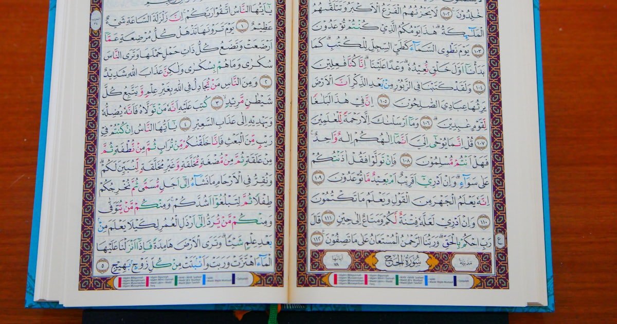 An open Quran with Arabic script resting on a wooden table